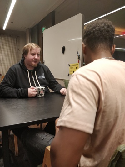 Juha-Matti coaching a young entrepreneur sitting at a table