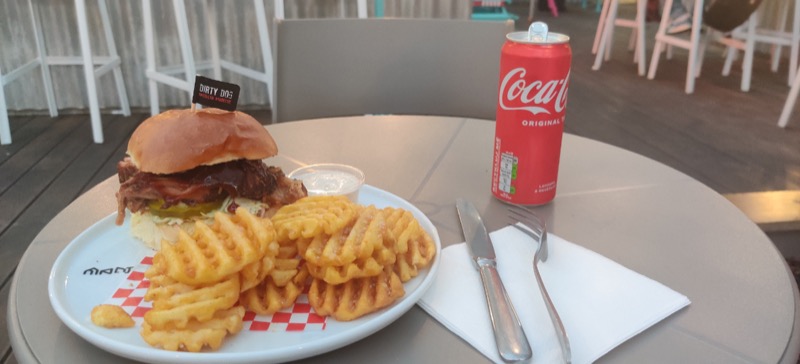 A burger with fries and a can of coke. 