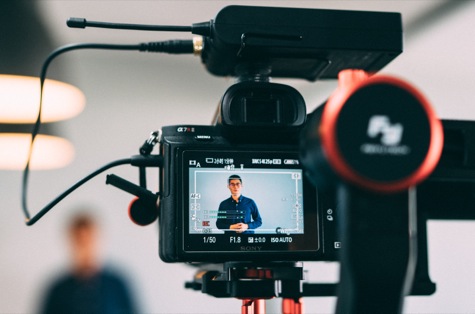 A video camera viewfinder with a man speaking to camera