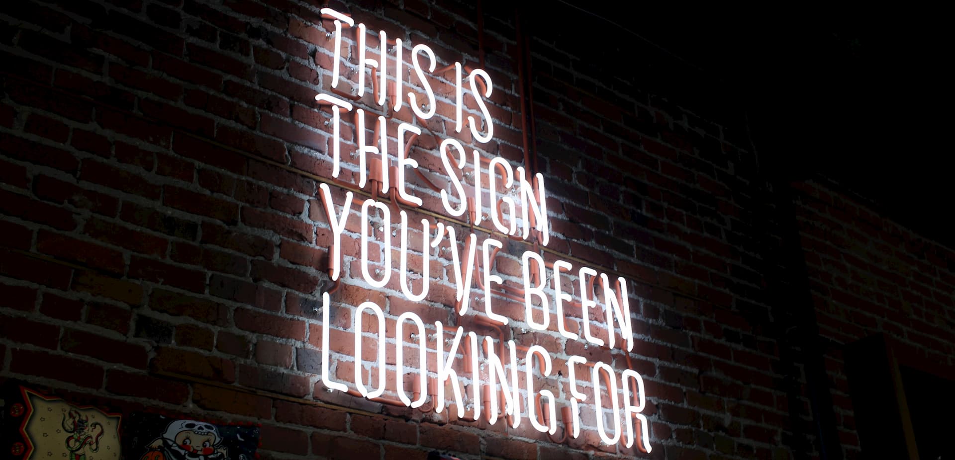 Neon sign on brick wall saying This is the sign you've been looking for