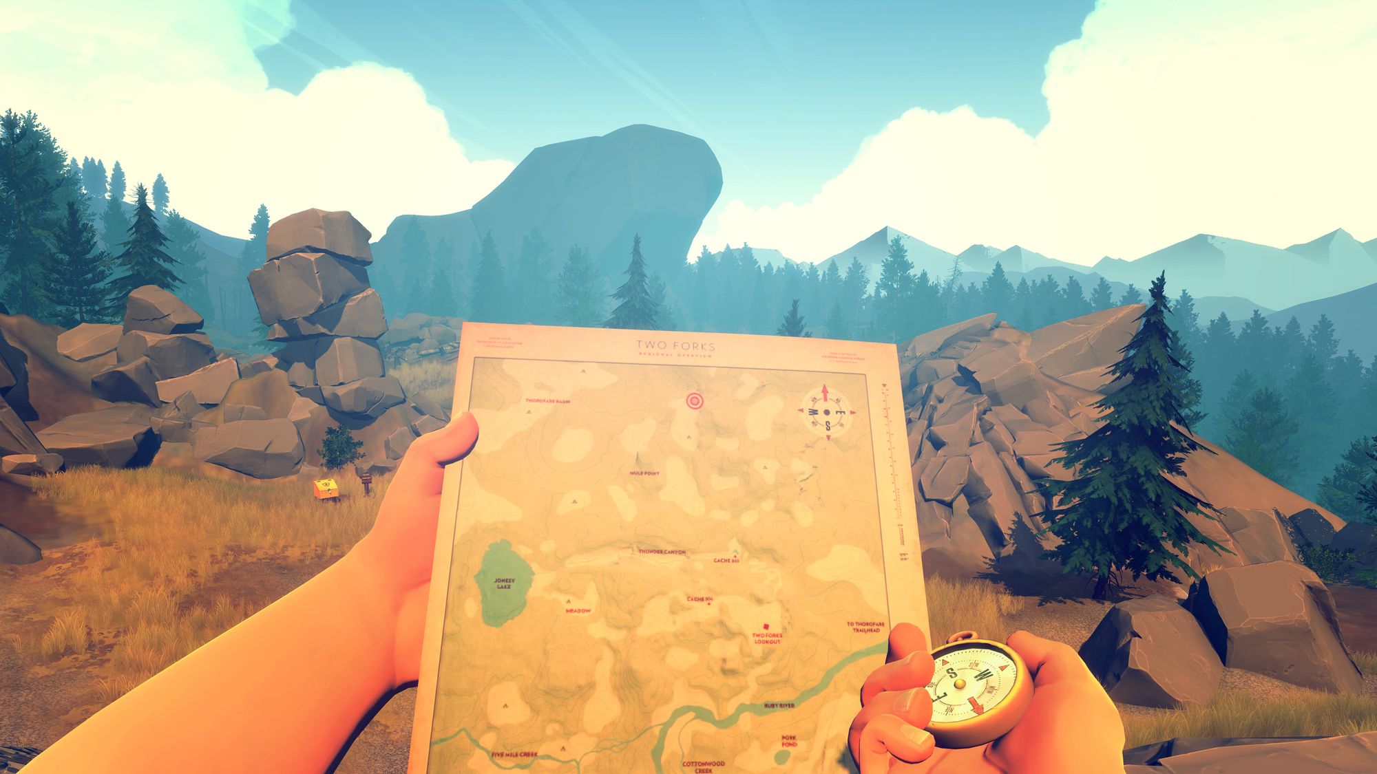 Man looking at a map and compass with wilderness in the background