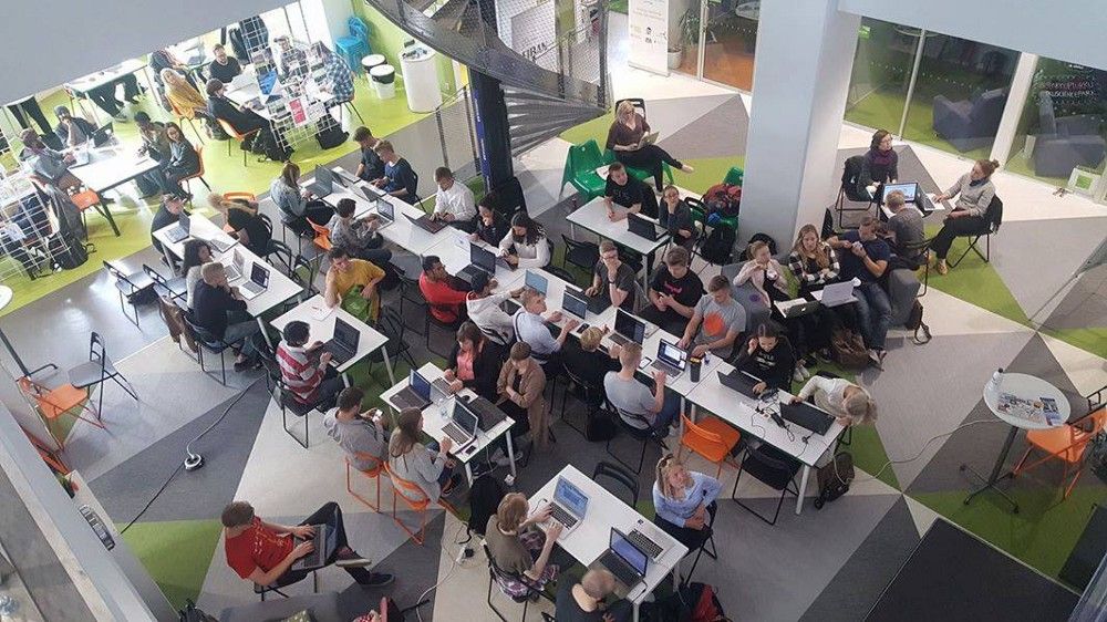 People working on their laptops in multiple rows of tables, photographed from above