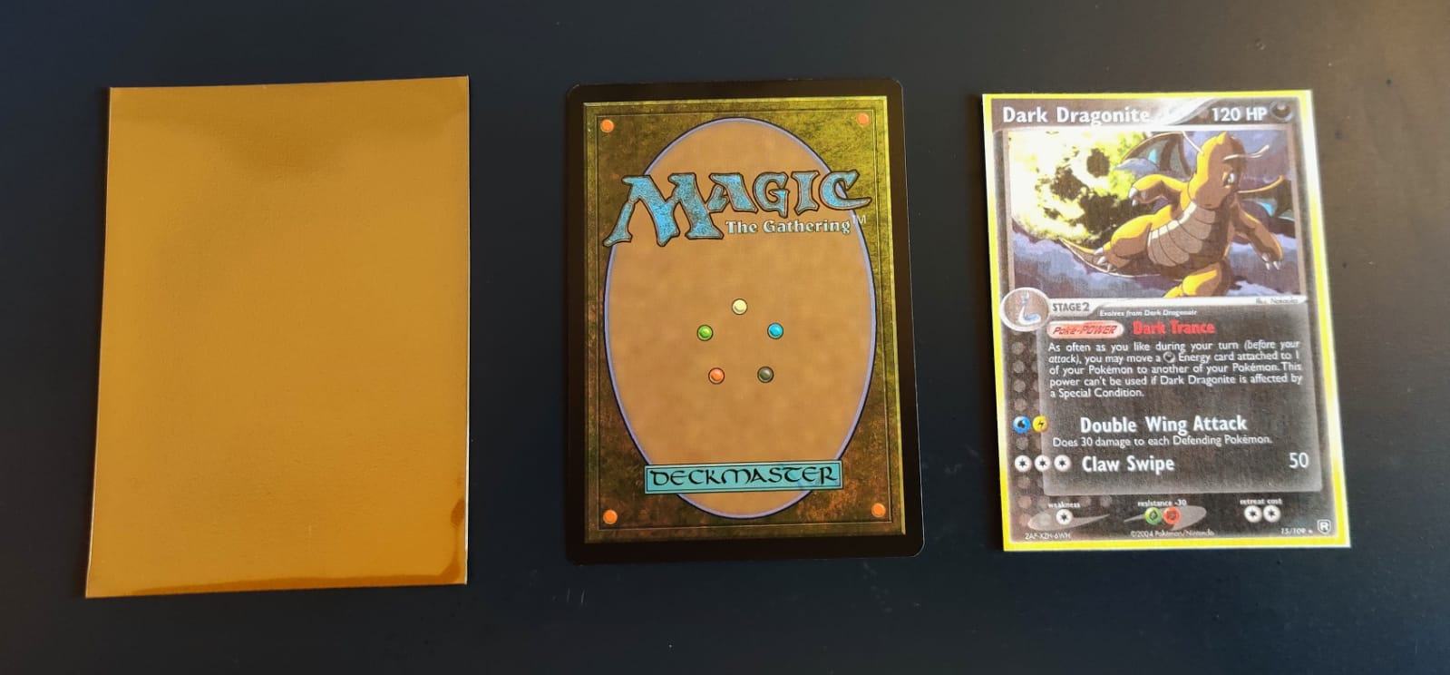 A card sleeve, a Magic the Gathering card upside down and a printed Dark Dragonite card