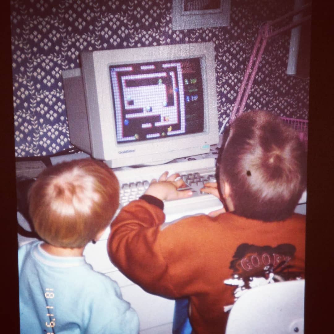 A picture from 1991, I'm standing next to my brother who's playing on a computer.