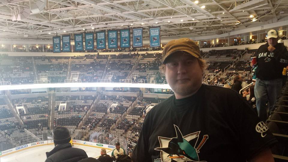 Me posing for the camera with San Jose Sharks hockey game on the background