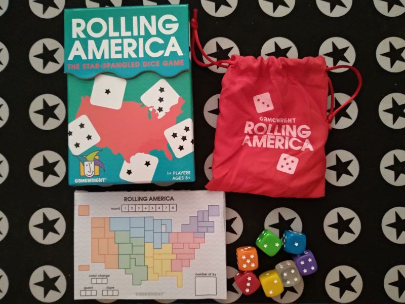 A box, a small cloth bag, 7 rainbow colored dice and a pad of game boards