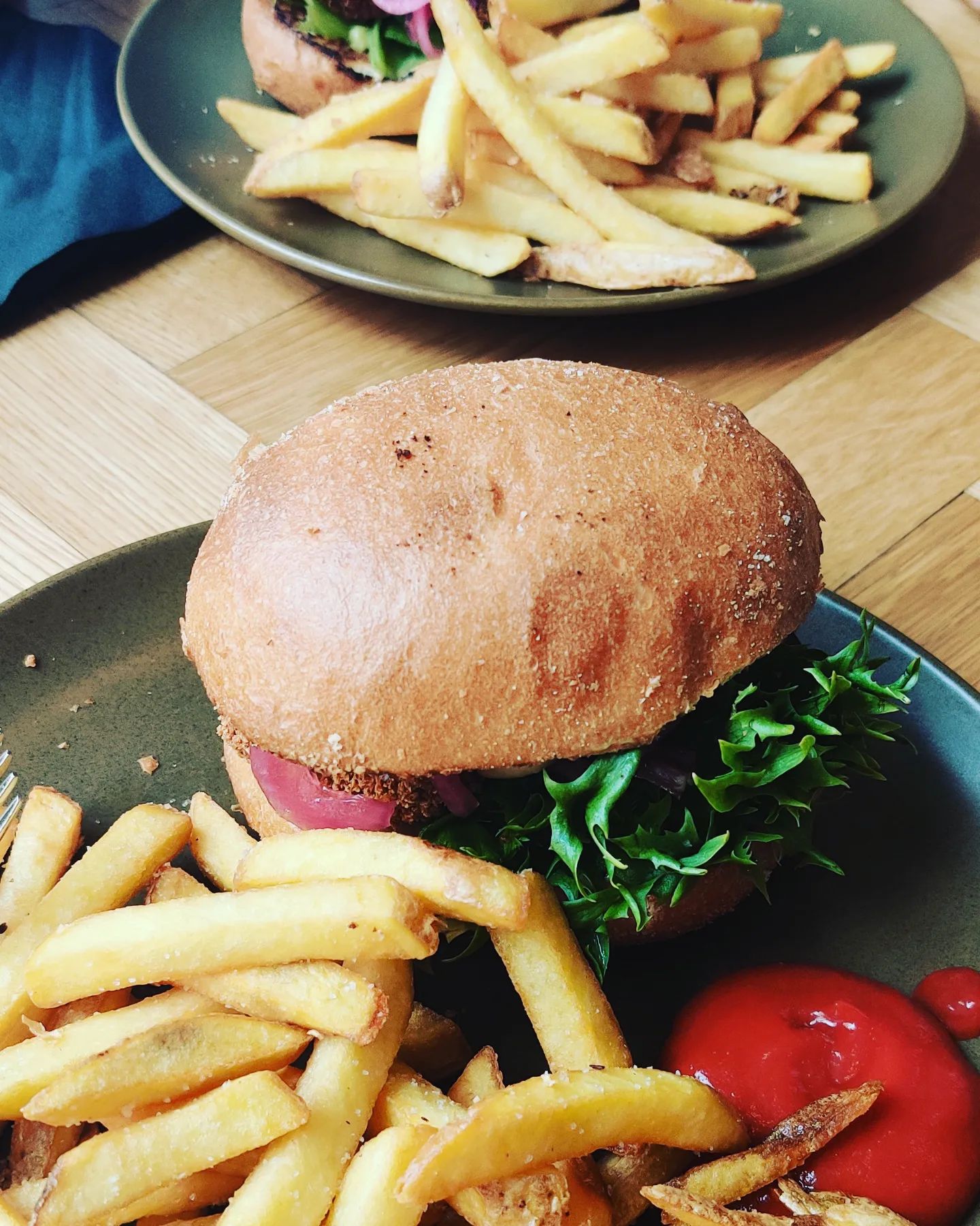 A delicious chicken burger with fries and ketchup on the side