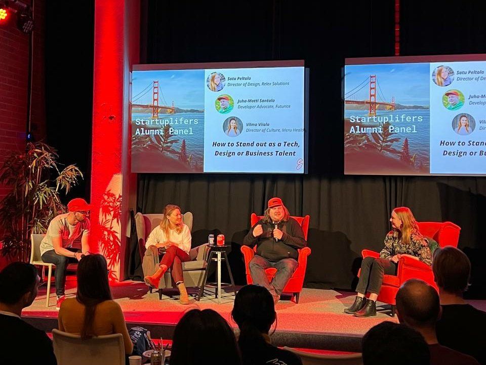 Four people on stage sitting in chairs during panel discussion