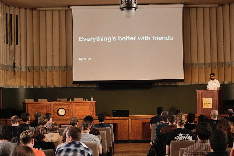 Sunil on the stage with a slide that reads 'Everything's better with friends'.