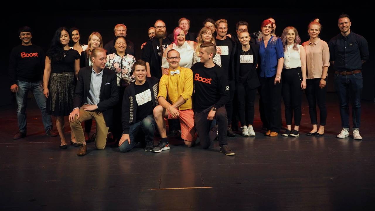 A group photo of about 30 people on a stage