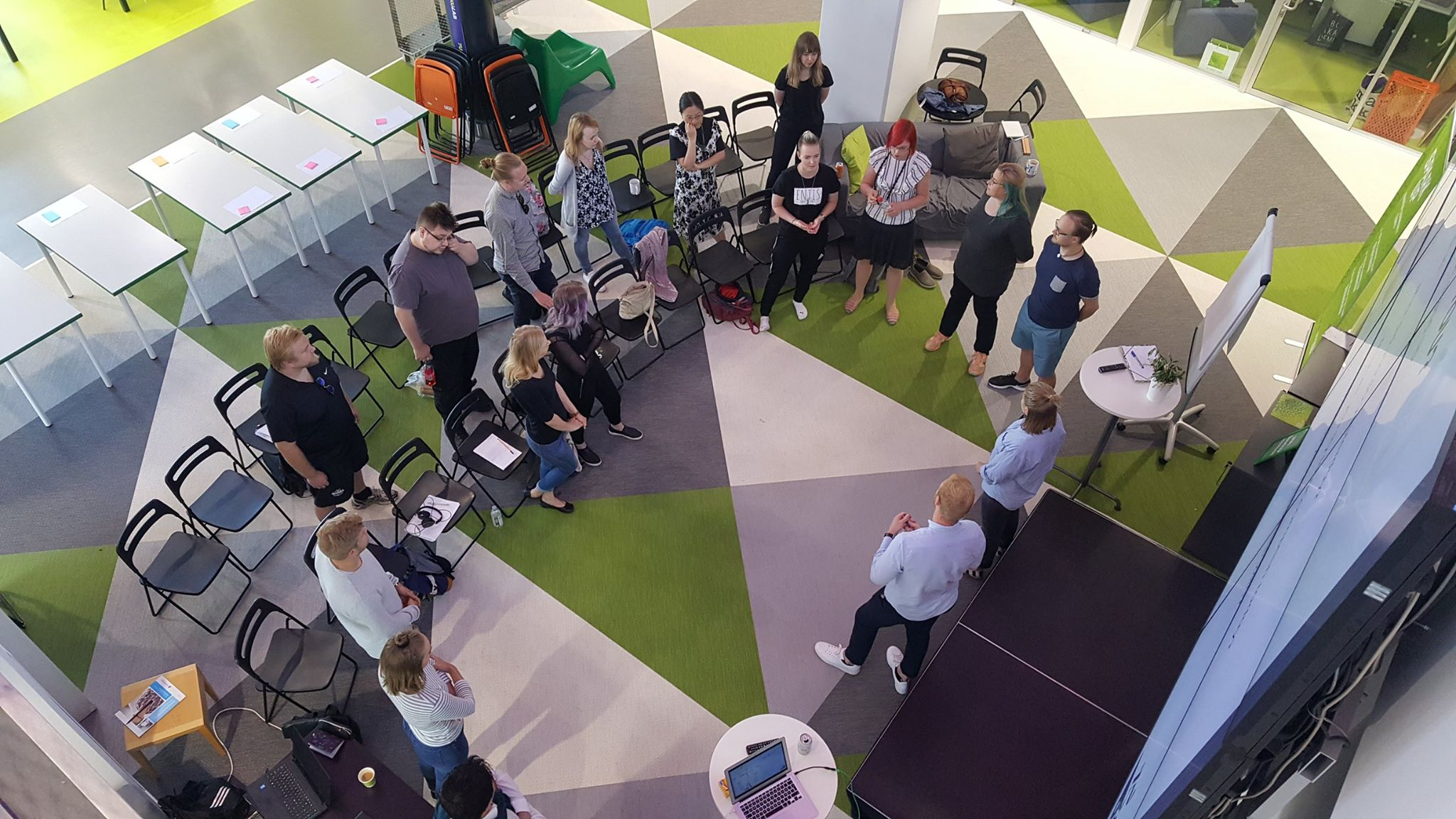 A group of people standing in a semicircle with two workshop hosts standing in the opening