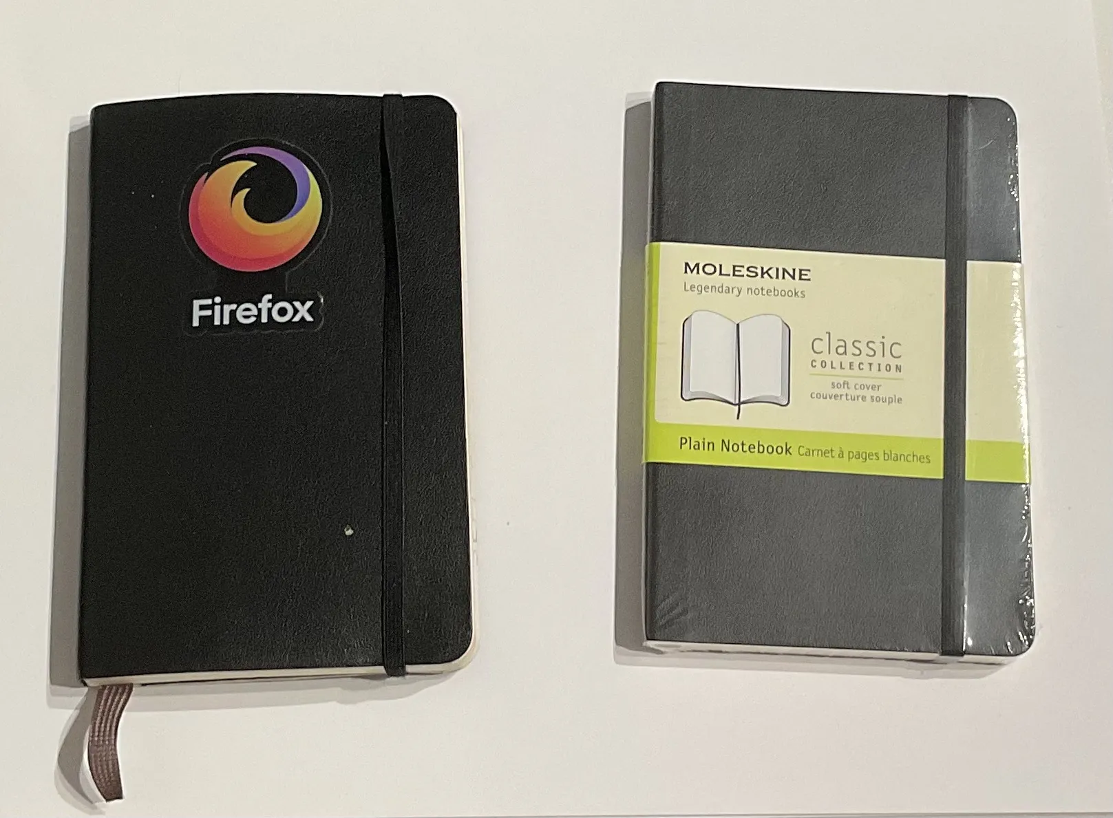 Two Moleskine pocket notebooks: one used with a Firefox sticker on the cover, other still in plastic wrap. 