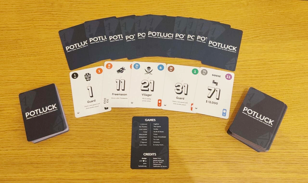 A deck with a few cards fanned out face-down, showing a dark blue background with white logo saying Potluck. Below them, five white cards face up showing numbers 1, 11, 21, 31 and 71 and a variety of other elements in the cards. Below them, a single card listing a bunch of games and credits for the project. 