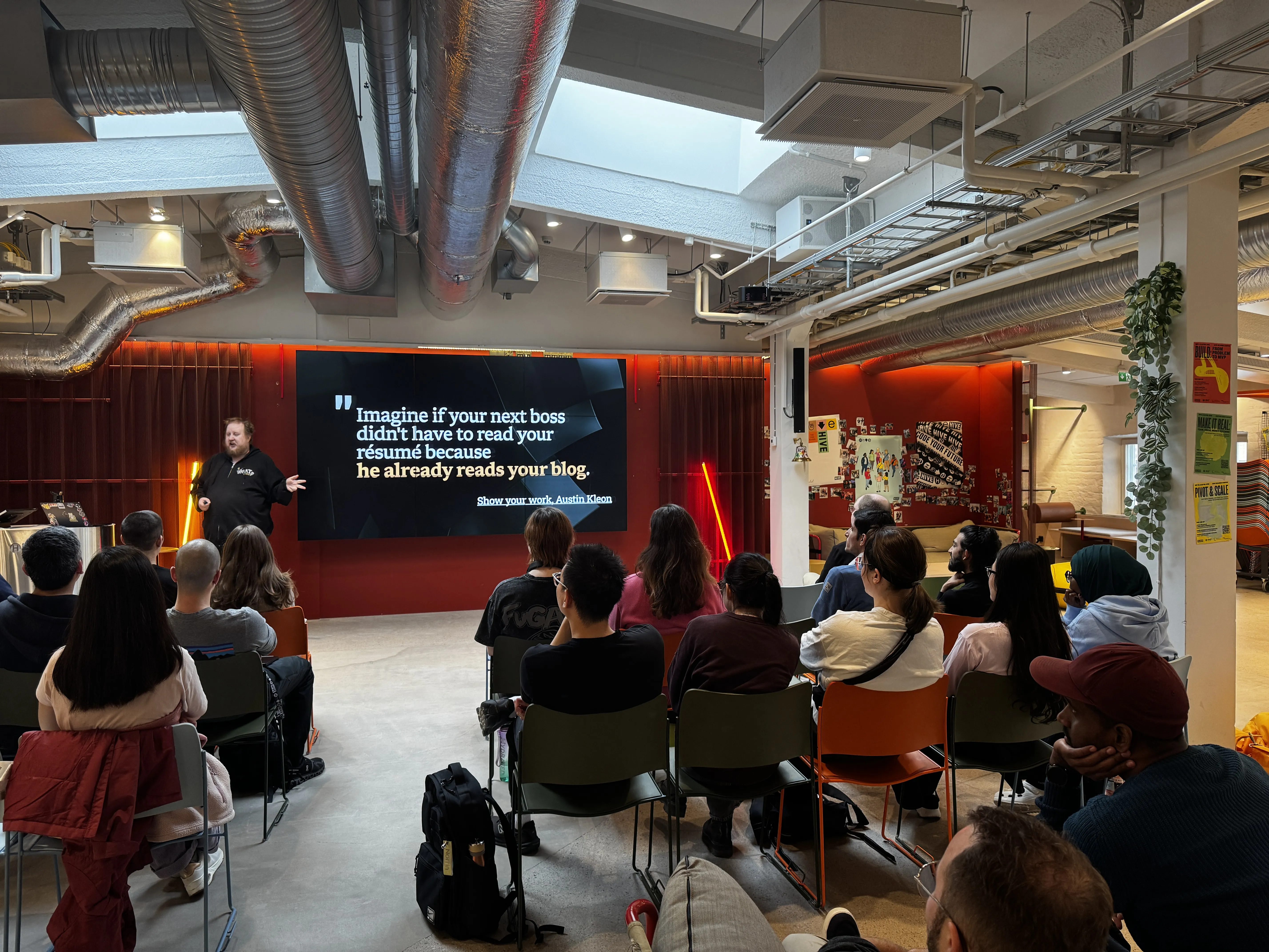 A room of people listening to Juhis talk. Next to him, a big screen shows a quote from Austin Kleon: Imagine if your
    next boss didn’t have to read your resume because he already reads you blog. 