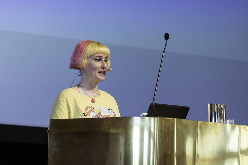 Jo speaking from behind a speaker podium 