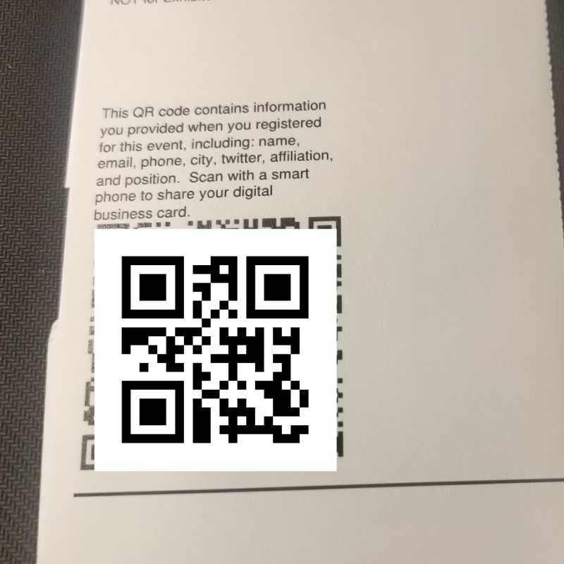 A backside of conference badge with a QR code and text “This QR code contains information you provided when you registered for this event, including: name, email, phone, city, twitter, affilaition and position. Scan with a smart phone to share your digital business card. 