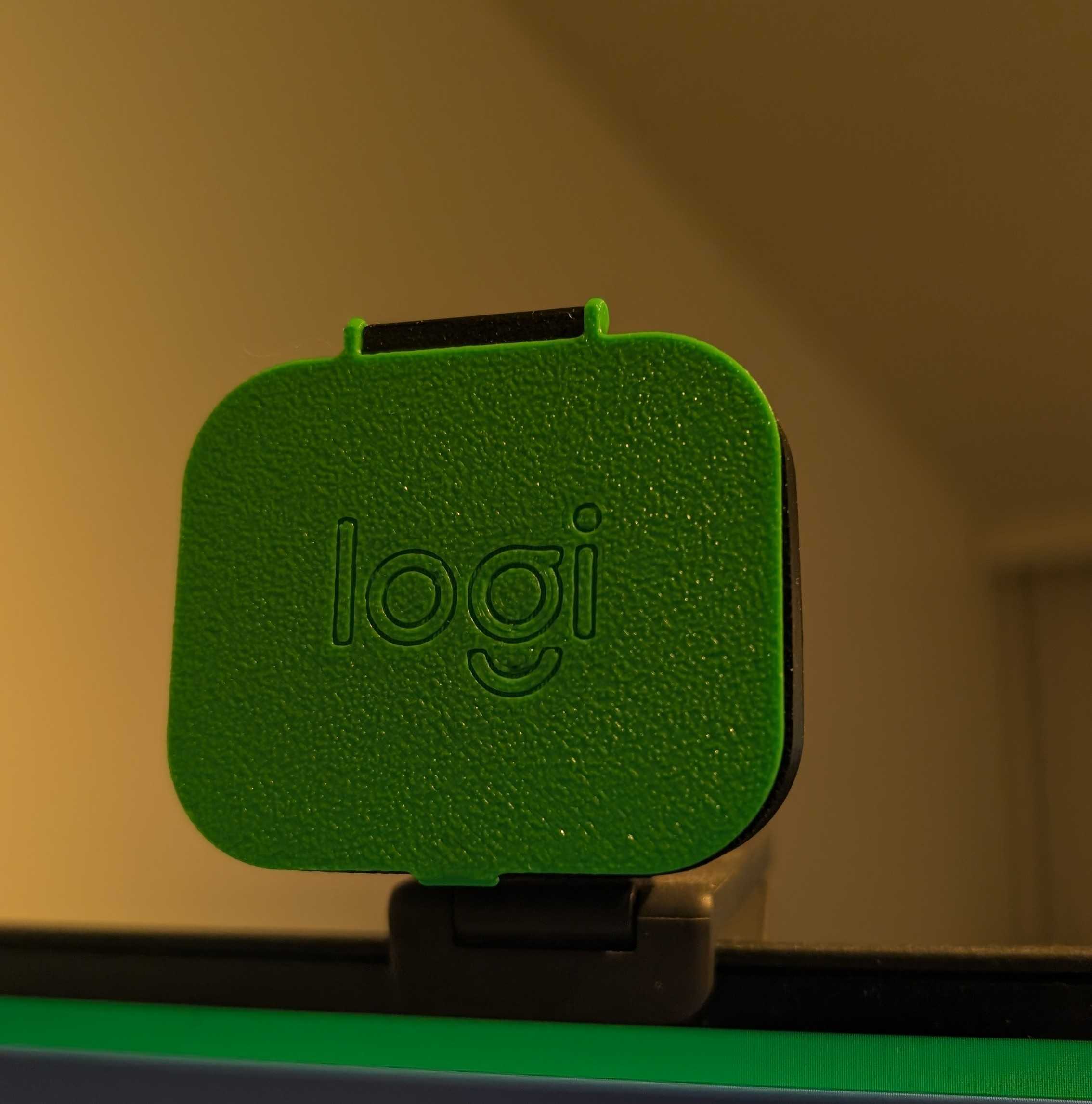 A bright green 3D printed cover in front of a webcam 