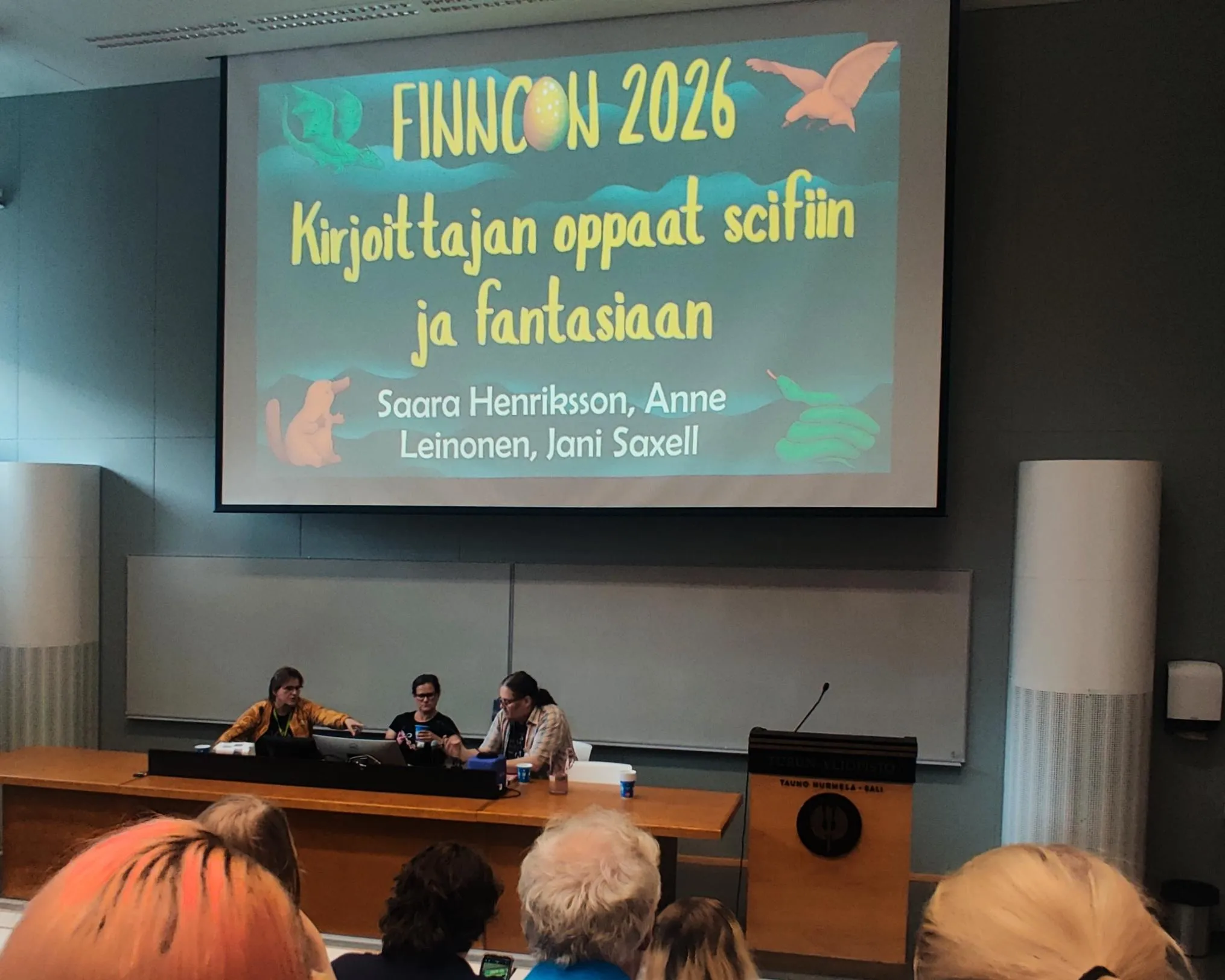 A panel discussion with three people in a university lecture hall 