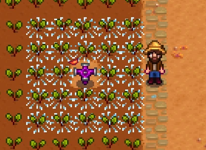 Screenshot of Stardew Valley with an iridium sprinkler being activated and watering crops. 