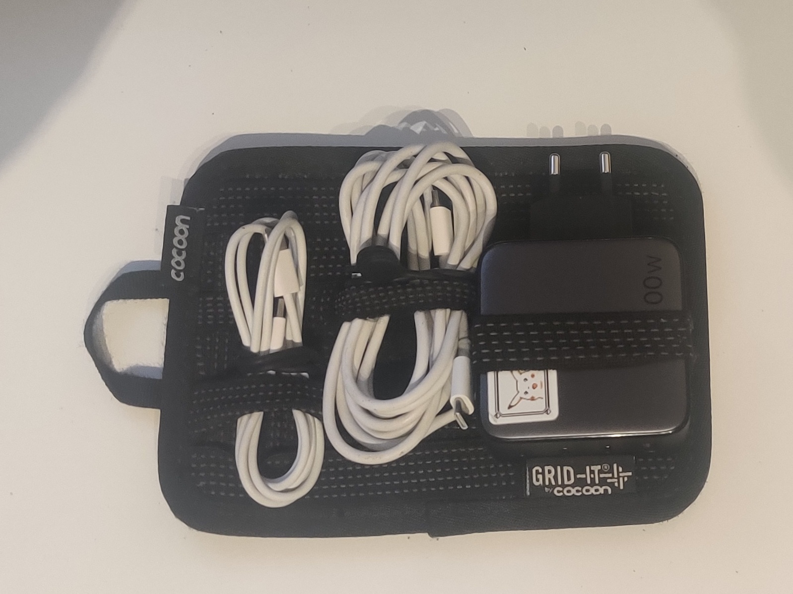 A Cocoon Grid-It organizer with two USB-C cables and a charger tucked in 