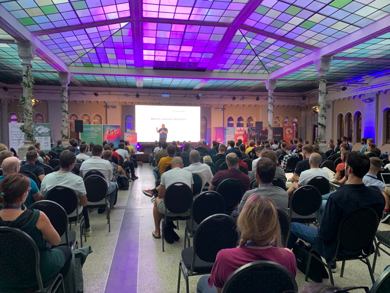 Me on a stage in front of a few hundred developrs sitting in the main hall of the conference 