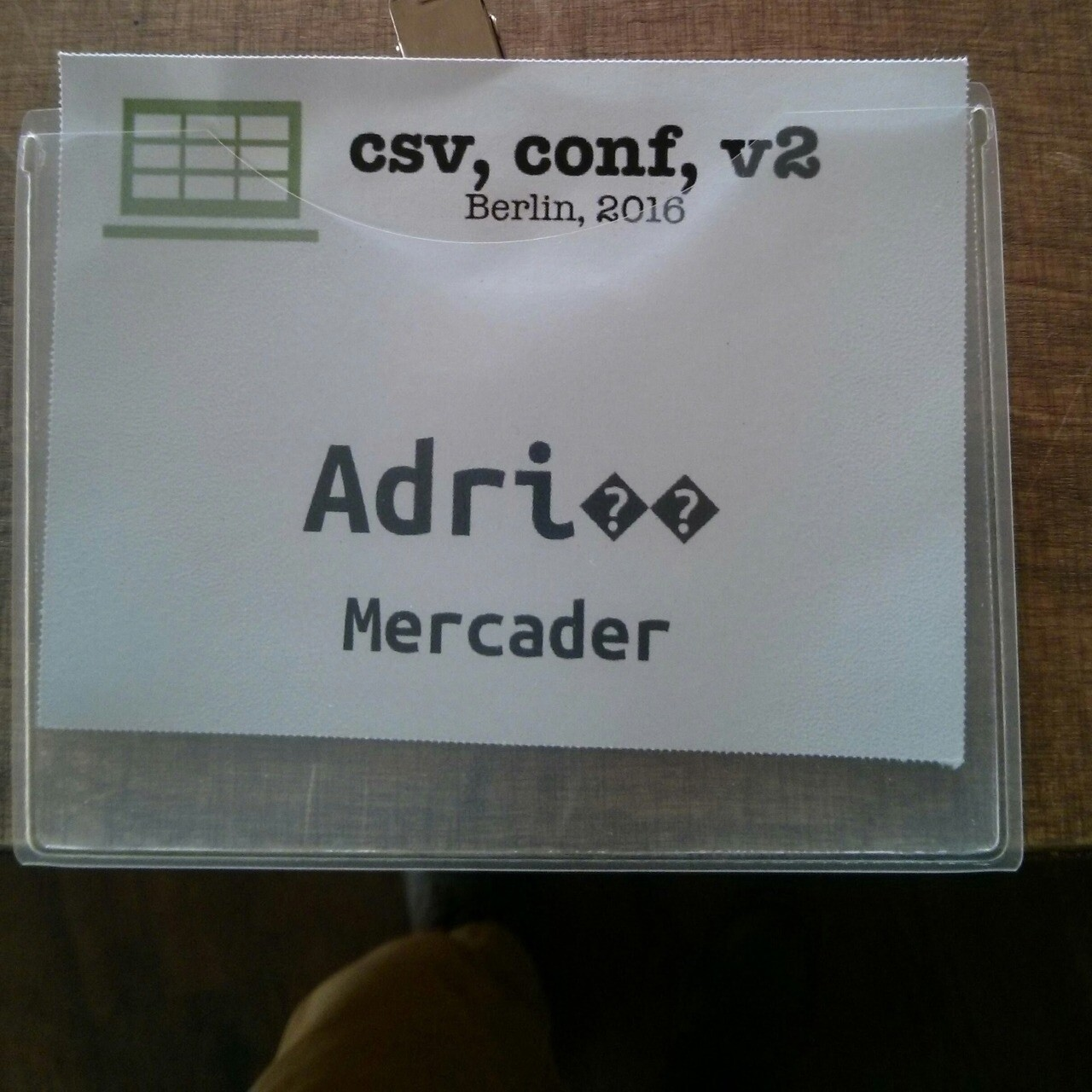 A conference badge of csv, conf 2016 for Adrià Mercader with first name written as “Adri” followed by two question marks in black triangles. 
