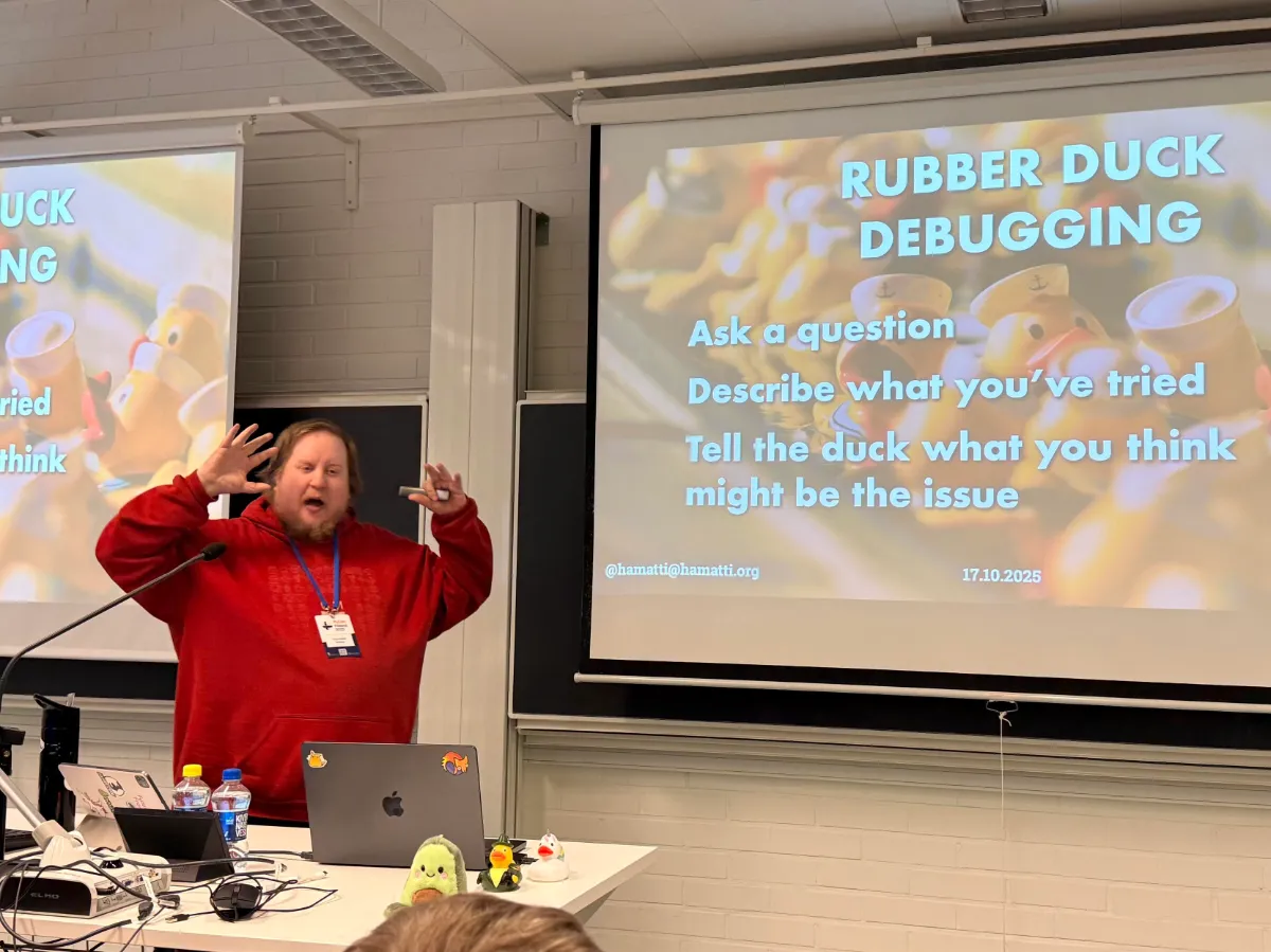 Juhis is speaking, waving his hands up in the air with a slide titled Rubber duck debugging on the screen. 