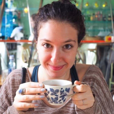 Closeup of Arielle looking at the camera holding a tea cup